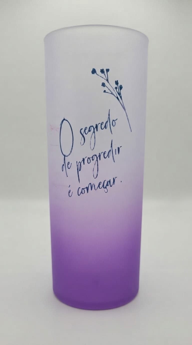 Copo long drink jateado com degradê roxo e a frase "O segredo de progredir é começar"